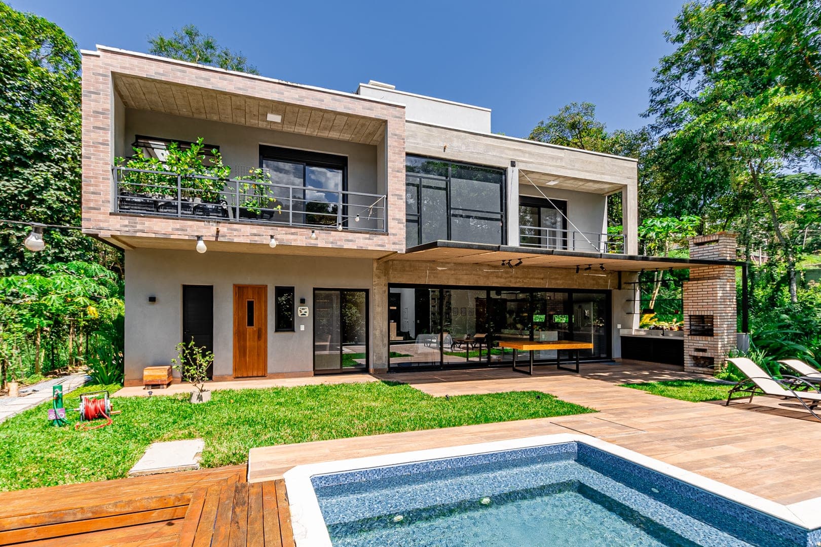 Exemplo de foto de fachada com jardim e piscina do acervo Piperz